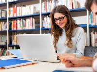 Lernort Bibliothek Studentin mit Laptop lernend in der Bibliothek