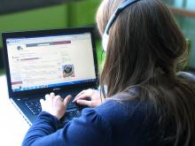 Frau mit Kopfhörer und Laptop