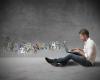 Student mit Laptop am Boden sitzend